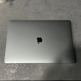 Silver laptop with Apple logo on a gray surface