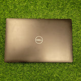 Dell Precision 3541 laptop in black color, closed, placed on green grass.