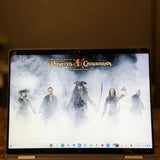 Laptop displaying 'Pirates of the Caribbean' movie poster on a dark background