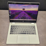 Open laptop displaying a scenic wallpaper on a gray surface