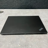 Black laptop on a gray surface with a dark background