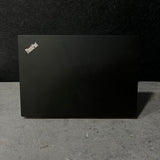 Black ThinkPad laptop on a dark surface