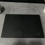 Black ThinkPad laptop on a concrete surface