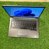 A silver Dell Latitude 7400 laptop on green background
