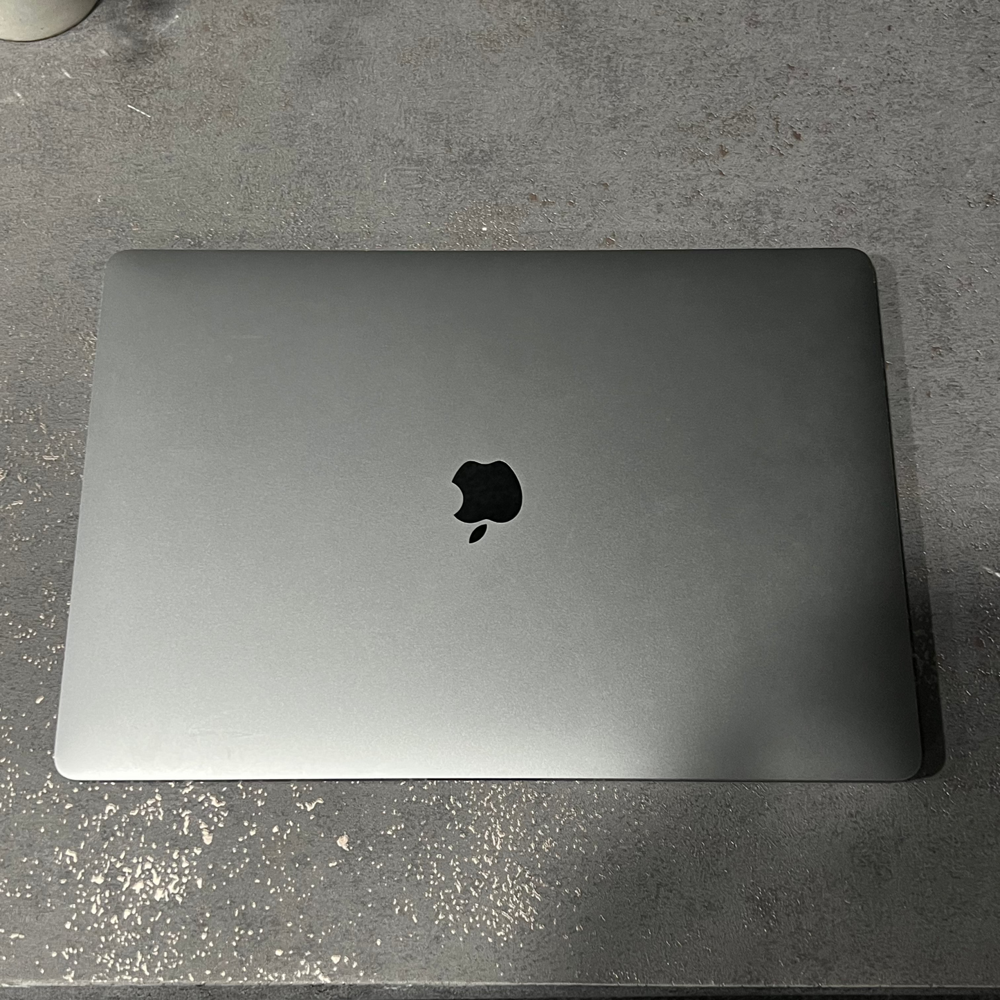 Silver laptop with Apple logo on a gray surface