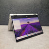 Open  HP ProBook x360 435 G8 Ryzen 7 Renewed Touchscreen Laptop displaying a scenic wallpaper on a gray surface with a dark textured wall background