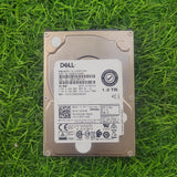 Dell 1.2TB 10K RPM 12Gbps 2.5" SAS hard drive lying on grass.