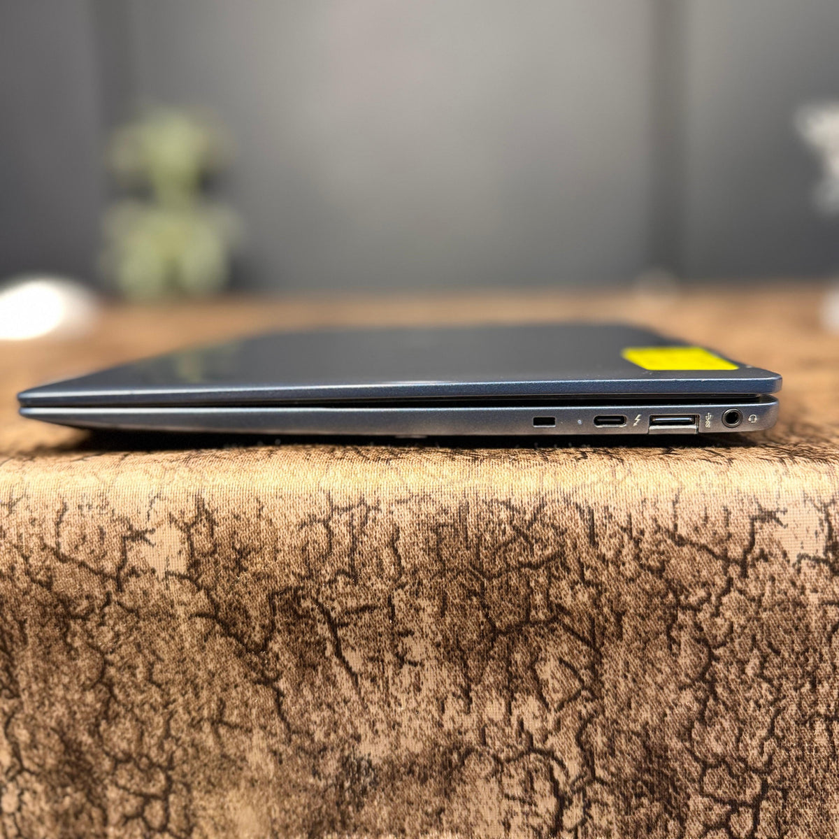 Laptop on a textured surface with a blurred background