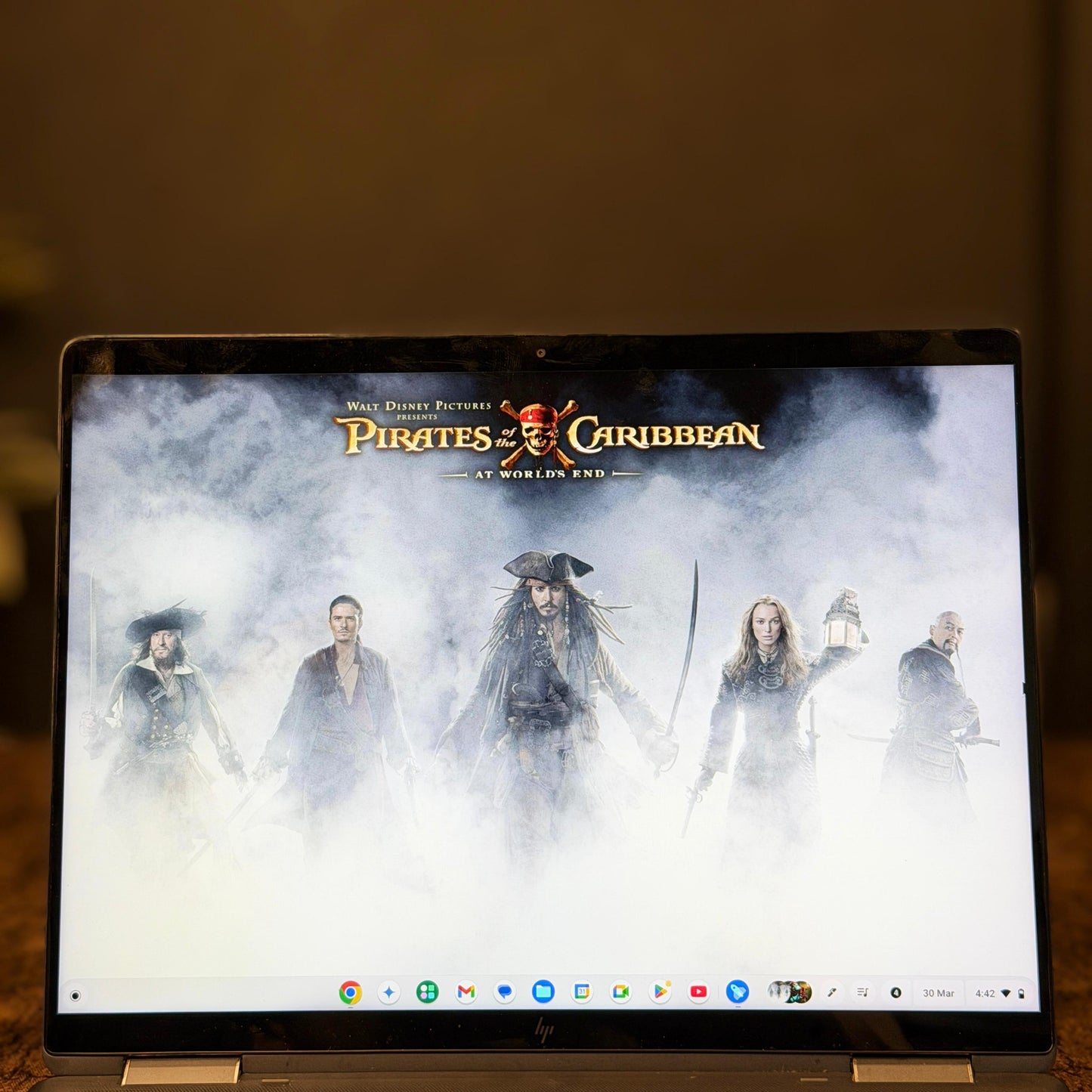 Laptop displaying 'Pirates of the Caribbean' movie poster on a dark background