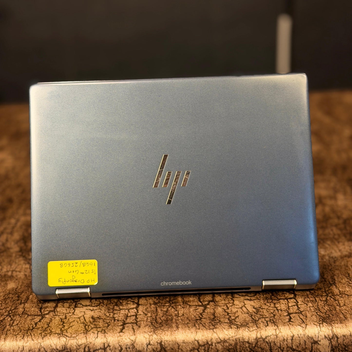 HP Chromebook on a textured surface with a blurred background