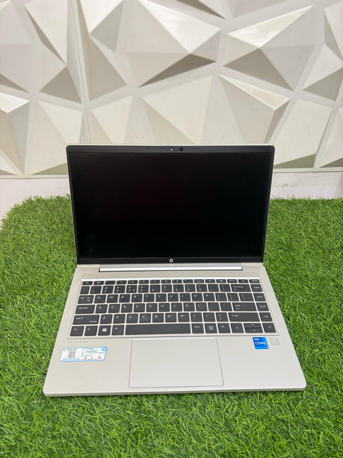 HP ProBook 440 G8 laptop with a silver color scheme, displayed on a grass-like surface 