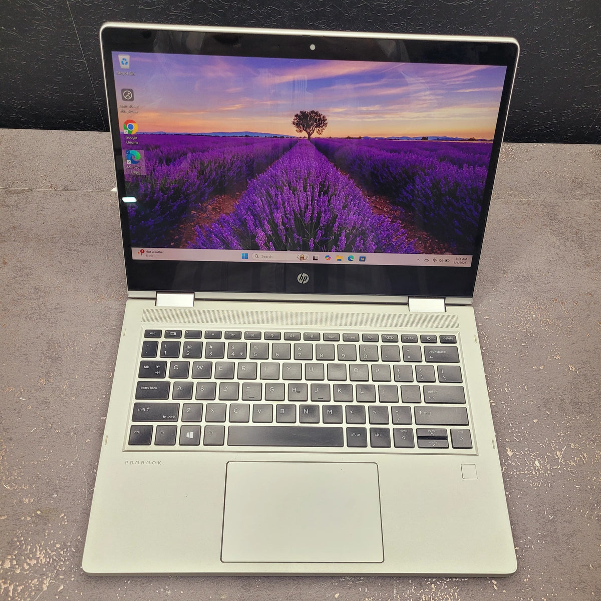 Open laptop displaying a scenic wallpaper on a gray surface