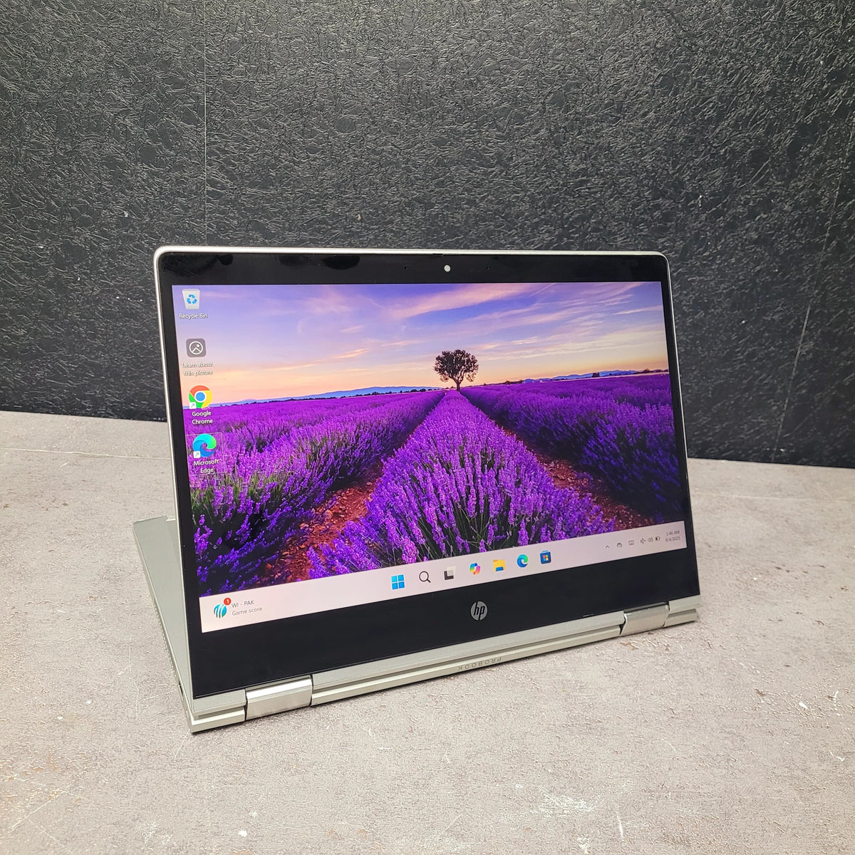 Laptop displaying a lavender field on the screen against a dark background