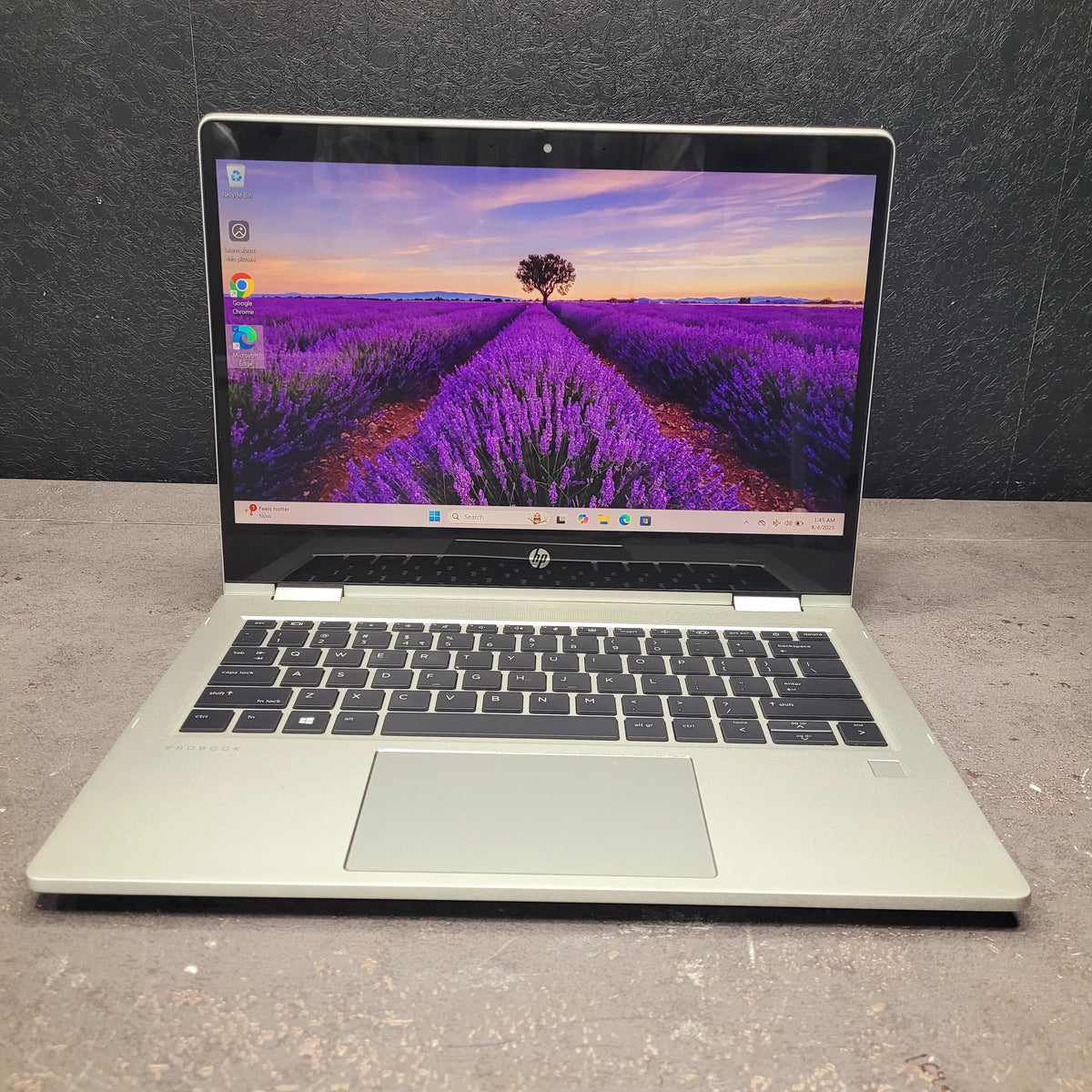Laptop with a lavender field on the screen against a dark background