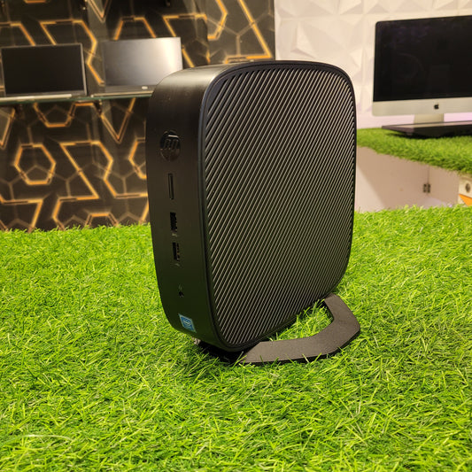 HP t638 Thin Client Computer placed on a grass-like surface, showing its black casing with a textured design.