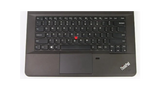 A black Lenovo ThinkPad laptop keyboard deck with a red TrackPoint nub, white lettering on the keys, and a touchpad below, shown against a plain white background.
