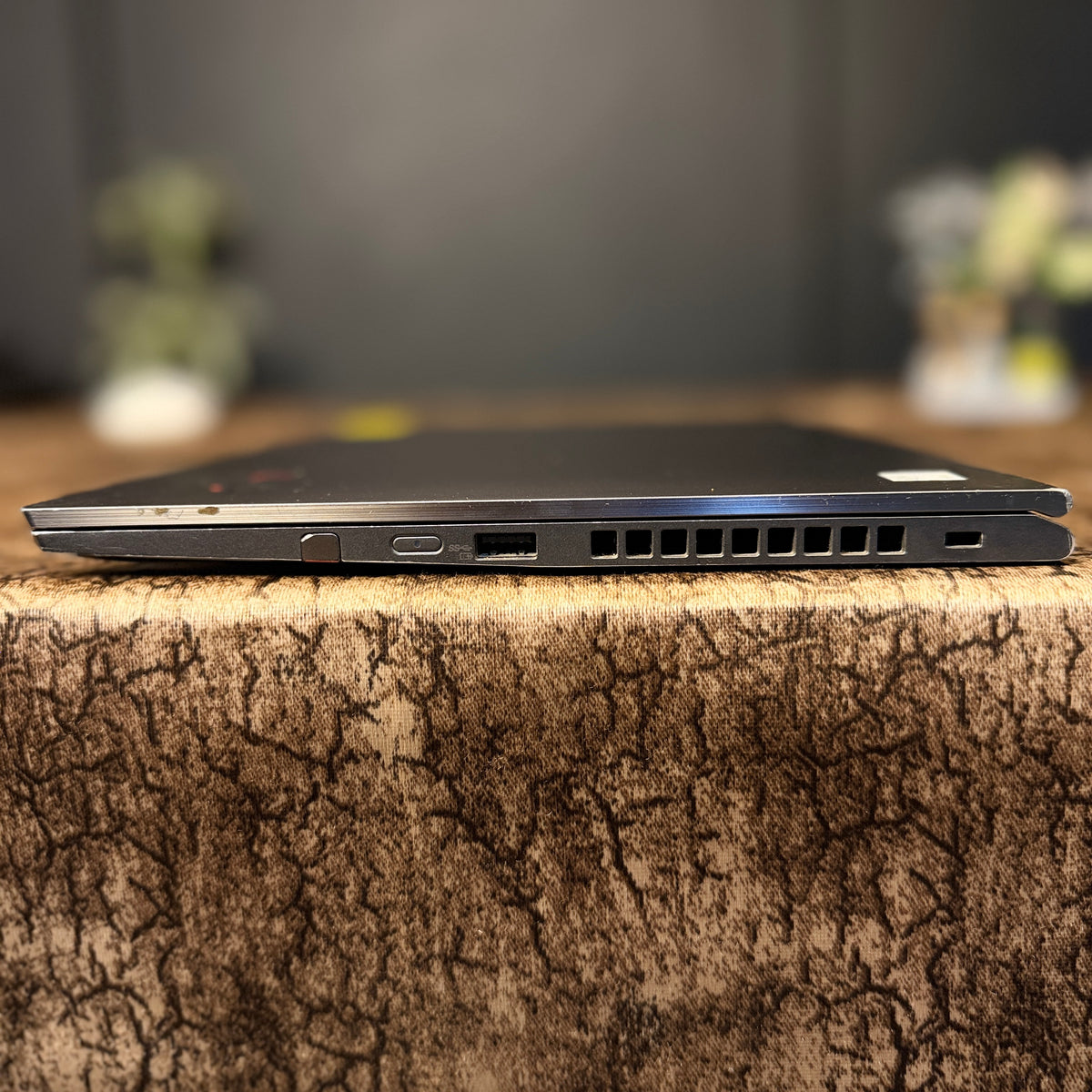 Laptop on a textured surface with a blurred background