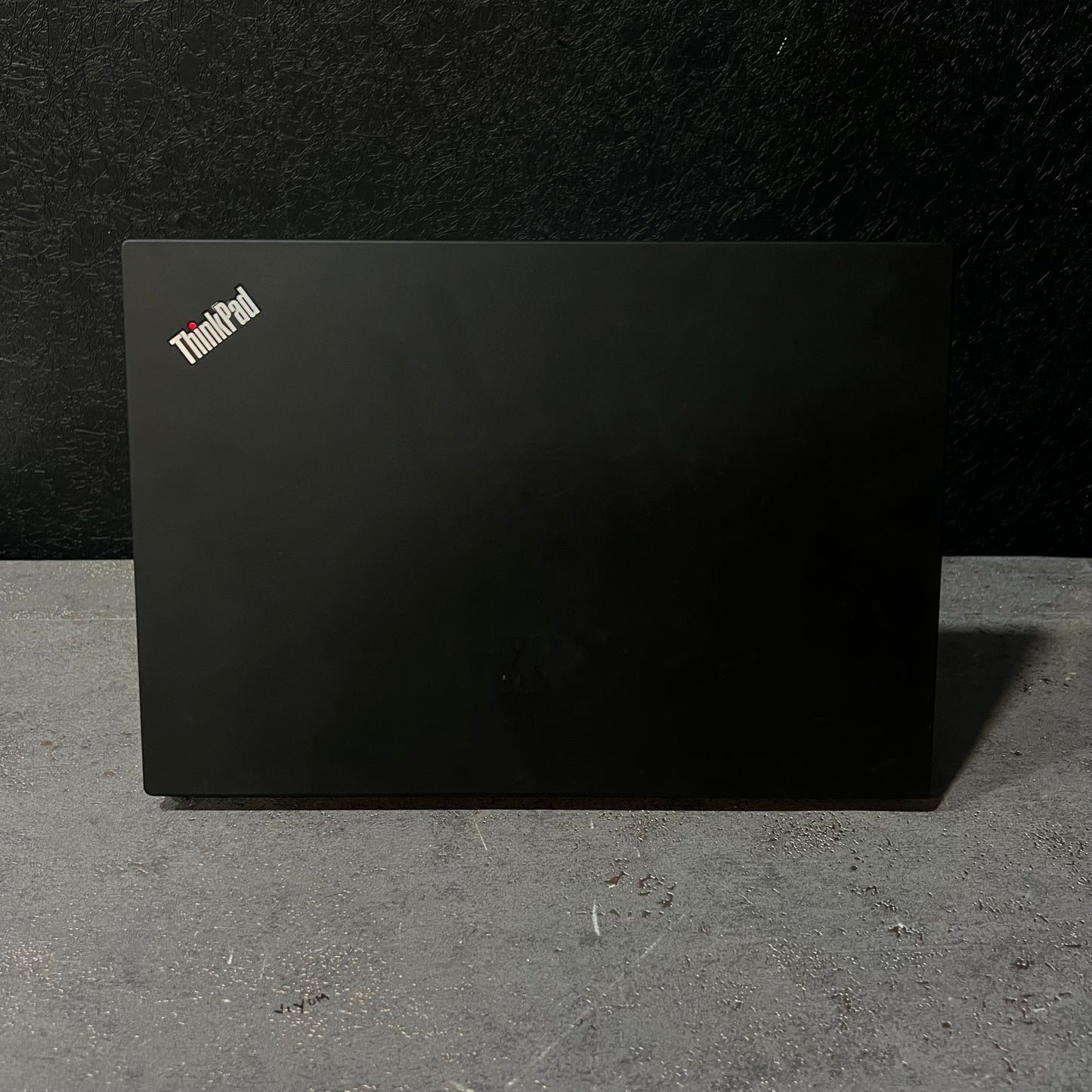 Black ThinkPad laptop on a dark surface