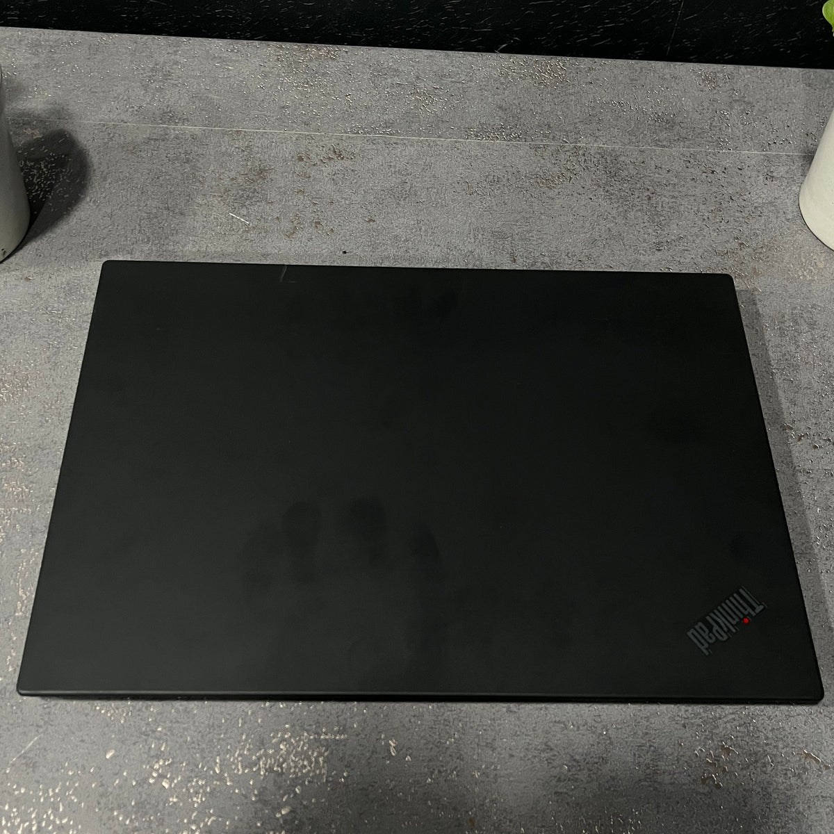 Black ThinkPad laptop on a concrete surface